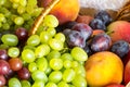 Close up heap of fresh fruits from new harvest poured out from wicker basket on wooden table. Royalty Free Stock Photo