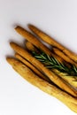 Heap of Italian grissini with rosemary on a white background