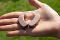 Close up of hearing aids in heart shape on hand with a natural green background Royalty Free Stock Photo