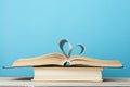 Heart from book page on blue background.Education concept.Copy space for text.