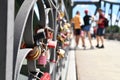 Close up of heart shaped love padlocks at bridge called `Eiserner Steg` in Frankfurt city with blurry tourists in background