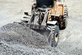 Close up of heavy duty large wheel loader loading gravel at work site