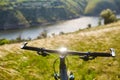 Close-up of helm of the mountain bicycle in the green grass against beautiful landscape.