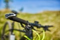 Close-up of helm of the mountain bicycle in the green grass against beautiful landscape.