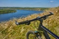 Close-up of helm of the mountain bicycle in the green grass against beautiful landscape.