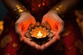 close-up of henna-decorated hands holding diyas