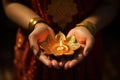 close-up of henna-decorated hands holding diyas