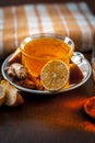 Close up of a herbal tea  consisting of apple juice,lemon,ginger and warm water in a transparent cup on a wooden surface in dark G Royalty Free Stock Photo