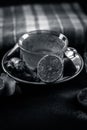 Close up of a herbal tea  consisting of apple juice,lemon,ginger and warm water in a transparent cup on a wooden surface in dark G Royalty Free Stock Photo