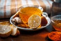 Close up of a herbal tea  consisting of apple juice,lemon,ginger and warm water in a transparent cup on a wooden surface in dark G Royalty Free Stock Photo