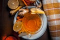 Close up of a herbal tea  consisting of apple juice,lemon,ginger and warm water in a transparent cup on a wooden surface in dark G Royalty Free Stock Photo