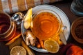 Close up of a herbal tea  consisting of apple juice,lemon,ginger and warm water in a transparent cup on a wooden surface in dark G Royalty Free Stock Photo