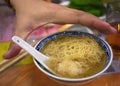 Close up High angle view a hand over the small bowl of hong kong wonton dumpling egg noodle soup, tradition local food, chinese Royalty Free Stock Photo