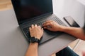 Close-up high-angle view of unrecognizable business man typing on laptop computer sitting at desk in light office room. Royalty Free Stock Photo