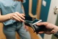 Close-up high-angle view of unrecognizable courier male giving POS wireless terminal to making contactless payment using Royalty Free Stock Photo