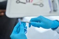 Close-up high-qualified dentist taking little rubber band to tie braces