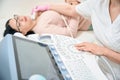 High-qualified woman sonographer performing ultrasound of the thyroid gland