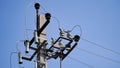 Close-up high voltage power line on a background of blue sky on a sunny day. Electro pole, pole with wires, live wires, Royalty Free Stock Photo