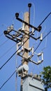 Close-up high voltage power line on a background of blue sky on a sunny day. Electro pole, pole with wires, live wires, Royalty Free Stock Photo