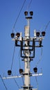 Close-up high voltage power line on a background of blue sky on a sunny day. Electro pole, pole with wires, live wires, Royalty Free Stock Photo