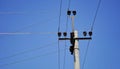 Close-up high voltage power line on a background of blue sky on a sunny day. Electro pole, pole with wires, live wires, Royalty Free Stock Photo