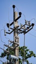 Close-up high voltage power line on a background of blue sky on a sunny day. Electro pole, pole with wires, live wires, Royalty Free Stock Photo