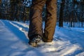 Close up of hiker shoes walking on the snow in the forest. Exploring woodland in winter time Royalty Free Stock Photo