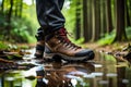 A close-up of hiking boots covered in mud and leaves, as they trudge through a dense forest trail Royalty Free Stock Photo