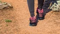 Close up of hiking boots, shoes and legs. Lady, girl, young woman hiking in nature, national park. Woman hiker legs on a rocky tra Royalty Free Stock Photo