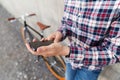 Close up of hipster man with smartphone and bike Royalty Free Stock Photo