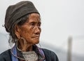 Close up of Hmong elderly woman against gray skies.