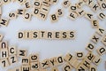 close-up holds wooden alphabet blocks on white background, changes word stress to distress, concept transient negative emotional