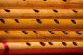 India, Close up of the holes of hindu bamboo flute called Bansuri on a red table.