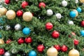 holiday decorations on tree, red, silver, gold and blue bulbs Royalty Free Stock Photo