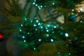 Close up of holiday electric blue garlands on fir branch with Christmas tree decoration and candy cane Royalty Free Stock Photo