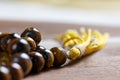 Close up of a holy Mala prayer beads necklace made of tiger eye gem stones with a yellow tassel promoting mediation healing and