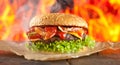Close-up of home made burgers with fire flames Royalty Free Stock Photo