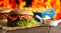 Close-up of home made burgers with fire flames Royalty Free Stock Photo