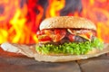 Close-up of home made burgers with fire flames Royalty Free Stock Photo