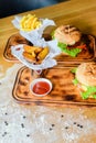 Close-up of home made tasty burgers and Fried Potatoes on wooden table. Royalty Free Stock Photo