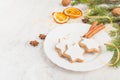 Close up of homemade butter nuts star shaped cookies with icing, pine, orange slices,cinnamon, anise, walnuts and golden ribbon Royalty Free Stock Photo