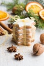 Close up of homemade butter nuts star shaped cookies with icing, pine, orange slices,cinnamon, anise, walnuts and golden ribbon Royalty Free Stock Photo