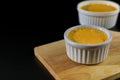 Close up homemade creme brulee in white ramekin  with sugar top up on black background with copy space. French dessert creme Royalty Free Stock Photo