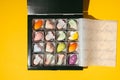 Close up of homemade multicolored chocolate bonbons in a gift box. Assortment of hand painted candies. Flat lay. Macro shot of Royalty Free Stock Photo