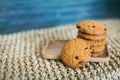 Homemade oatmeal cookies folded in a pile on wooden plate and wooden background