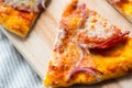 Close Up Of Homemade Pizza Slice On Wooden Table