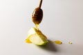 Close-up of honey dipping on granny smith apple slice over white background, copy space Royalty Free Stock Photo