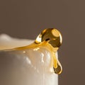Close-up of a honey drop sliding down the edge of a white surface, possibly a smooth Royalty Free Stock Photo