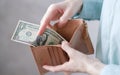 Close up of hopeless woman open her empty wallet and found only one dollar bill. Royalty Free Stock Photo