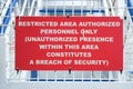 Close-Up Horizontal Frame of a Red Restricted Area Authorized Personnel Only Warning Sign on a White Metal Fence. Security Concept Royalty Free Stock Photo